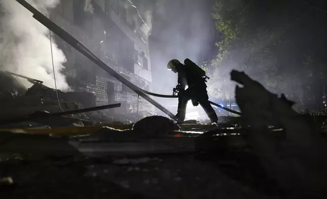 A rescuer works on a site of a residential building destroyed by a Russian strike in Zaporizhzhia, Ukraine, Thursday, May 1, 2025. (AP Photo/Kateryna Klochko)