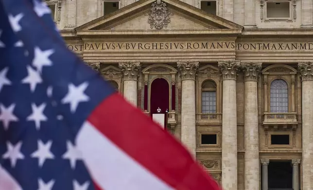 A flag from the United States waves from the crowd as Pope Leo XIV appears at the central balcony of St. Peter's Basilica for his first Sunday blessing after his election, in St. Peter's Square at the Vatican, Sunday, May 11, 2025.(AP Photo/Bernat Armangue)