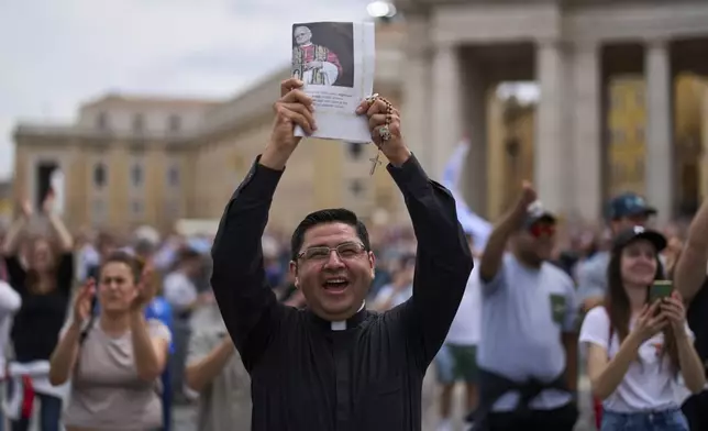 A priest celebrates as Pope Leo XIV appears at the central balcony of St. Peter's Basilica for his first Sunday blessing after his election, in St. Peter's Square at the Vatican, Sunday, May 11, 2025.(AP Photo/Bernat Armangue)