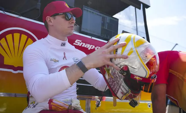 Josef Newgarden checks his helmet as he waits for the start of practice for the Indianapolis 500 auto race at Indianapolis Motor Speedway in Indianapolis, Friday, May 16, 2025. (AP Photo/Michael Conroy)