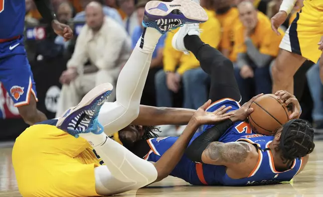 New York Knicks guard Miles McBride, right, tries to control the ball next to Indiana Pacers center Myles Turner during the second half of Game 3 of the Eastern Conference finals of the NBA basketball playoffs Sunday, May 25, 2025, in Indianapolis. (AP Photo/AJ Mast)