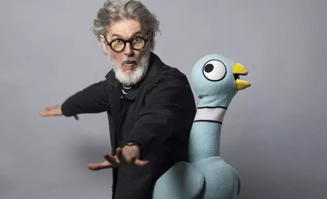 Author Mo Willems poses with The Pigeon, a character in his children's books, on April 22, 2025, in New York. (AP Photo/Gary Gerard Hamilton)