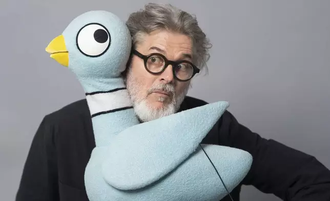Author Mo Willems poses with The Pigeon, a character in his children's books, on April 22, 2025, in New York. (AP Photo/Gary Gerard Hamilton)