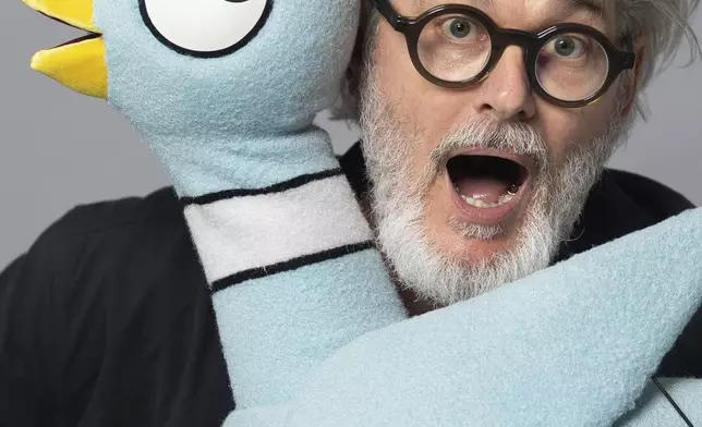 Author Mo Willems poses with The Pigeon, a character in his children's books, on April 22, 2025, in New York. (AP Photo/Gary Gerard Hamilton)