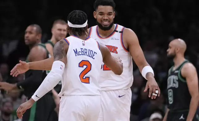 New York Knicks center Karl-Anthony Towns, rear, is congratulated by guard Miles McBride (2) during the first half of Game 5 of an NBA basketball second-round playoff series against the Boston Celtics, Wednesday, May 14, 2025, in Boston. (AP Photo/Charles Krupa)