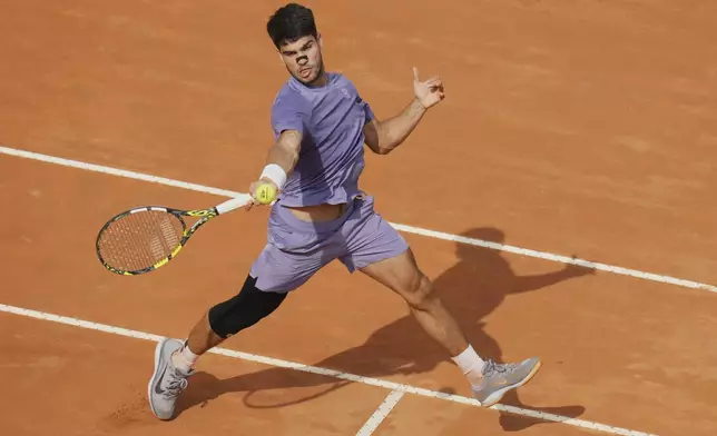 Spain's Carlos Alcaraz returns the ball to Britain's Jack Draper in their quarter-final tennis match at the Italian Open at the Foro Italico, in Rome, Wednesday, May 14, 2025.(AP Photo/Alessandra Tarantino)