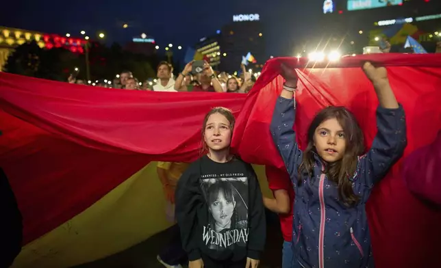 Children watch presidential candidate Nicusor Dan during an electoral rally of, a week ahead of the second round of the country's presidential election redo in Bucharest, Romania, Sunday, May 11, 2025. (AP Photo/Vadim Ghirda)