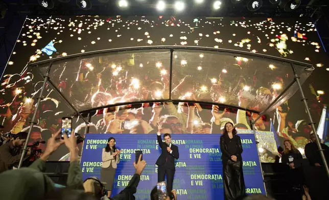 Presidential candidate Nicusor Dan, waves to supporters during an electoral rally, a week ahead of the second round of the country's presidential election redo in Bucharest, Romania, Sunday, May 11, 2025. (AP Photo/Vadim Ghirda)