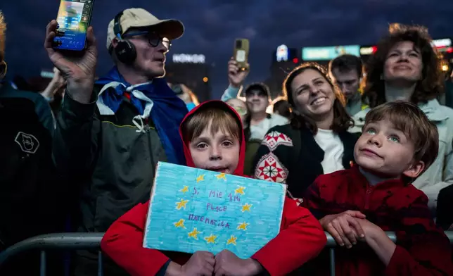 A child holds a drawing of an European Union flag which reads "I too like Mathematics" during an electoral rally of presidential candidate Nicusor Dan, a week ahead of the second round of the country's presidential election redo in Bucharest, Romania, Sunday, May 11, 2025. (AP Photo/Andreea Alexandru)
