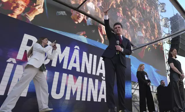 Presidential candidate Nicusor Dan waves during an electoral rally a week ahead of the second round of the country's presidential election redo in Bucharest, Romania, Sunday, May 11, 2025. (AP Photo/Andreea Alexandru)