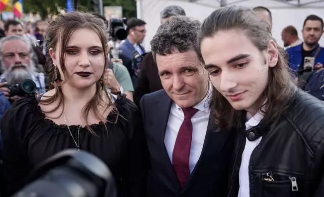 Presidential candidate Nicusor Dan, center, poses with supporters during an electoral rally a week ahead of the second round of the country's presidential election redo in Bucharest, Romania, Sunday, May 11, 2025. (AP Photo/Andreea Alexandru)