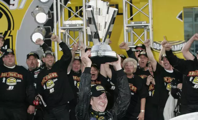 Nascar driver Kurt Busch raises the Nextel 2004 Cup Championship trophy Sunday Nov. 21, 2004 at the Homestead Miami Speedway in Homestead, Fla. (AP Photo/Terry Renna, File)