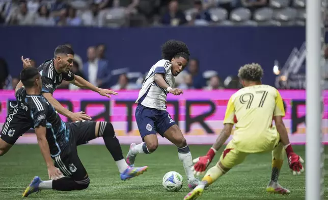 Vancouver Whitecaps' Jayden Nelson, back centre, attempts a shot against Minnesota United goalkeeper Dayne St. Clair (97) as Michael Boxall, back left, and Nicolas Romero, front left, defend during the second half of an MLS soccer match, in Vancouver, on Wednesday, May 28, 2025. (Darryl Dyck/The Canadian Press via AP)
