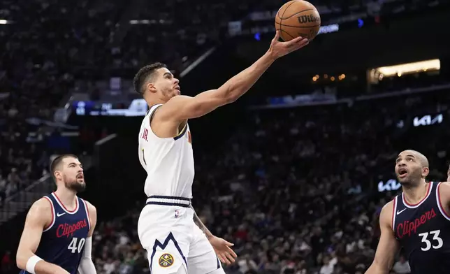 Denver Nuggets forward Michael Porter Jr., center, shoots as Los Angeles Clippers center Ivica Zubac, left, and forward Nicolas Batum defend during the second half in Game 6 of an NBA basketball first-round playoff series Thursday, May 1, 2025, in Inglewood, Calif. (AP Photo/Mark J. Terrill)