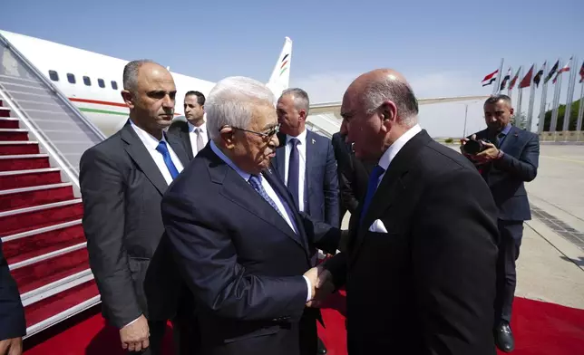 Iraqi Foreign Minister Fuad Hussein, right, welcomes Palestinian President Mahmoud Abbas upon arrival at Baghdad International Airport ahead of the 34th Arab League summit, in Baghdad, Iraq, Friday May 16, 2025. (Murtadha Al-Sudani/Pool Photo via AP)