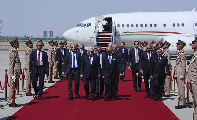 Iraqi Foreign Minister Fuad Hussein, center right, welcomes Palestinian President Mahmoud Abbas upon arrival at Baghdad International Airport ahead of the 34th Arab League summit, in Baghdad, Iraq, Friday May 16, 2025. (Murtadha Al-Sudani/Pool Photo via AP)