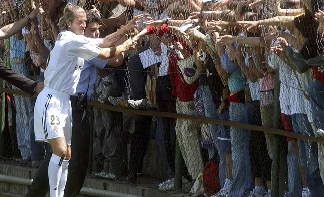 FILE - English soccer player David Beckham greets fans after his presentation by Real Madrid in Madrid, Spain, July 21, 2003. (AP Photo/Paul White, File)