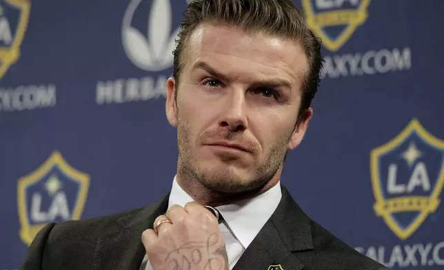 FILE - Los Angeles Galaxy's David Beckham fixes his tie during a news conference in Los Angeles, Jan. 19, 2012. (AP Photo/Jae C. Hong, File)