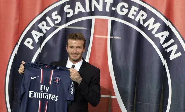 FILE - British soccer player David Beckham poses with his new jersey in front of the PSG logo during a press conference, at the Parc des Princes stadium in Paris, Thursday, Jan. 31, 2013 .(AP Photo/Michel Euler, File)