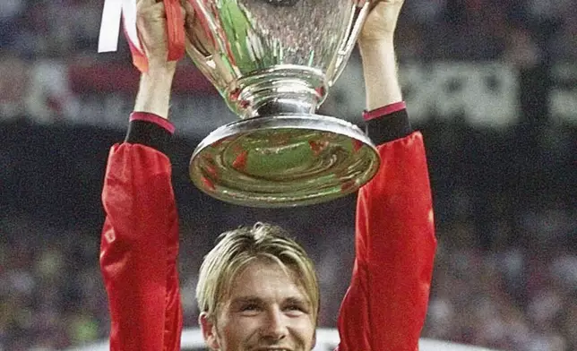 Manchester United's midfielder David Beckham holds the winner's cup, after his side defeated Bayern Munich in their Champions League final football match, at the Nou Camp stadium in Barcelona, Spain, May 25, 1999. (Phil Noble/PA via AP)
