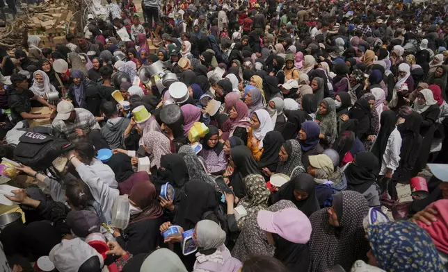 Palestinians struggle in a crowd as they try to receive donated food at a distribution center in Nuseirat, central Gaza Strip, Wednesday, April 30, 2025. (AP Photo/Abdel Kareem Hana)