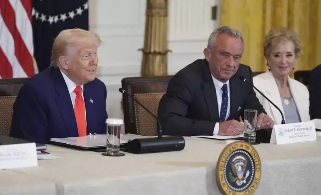 President Donald Trump, left, speaks as Education Secretary Linda McMahon, right, and Health and Human Services Secretary Robert F. Kennedy Jr. listen at a Make America Healthy Again (MAHA) Commission Event in the East Room of the White House, Thursday, May 22, 2025, in Washington. (AP Photo/Jacquelyn Martin)