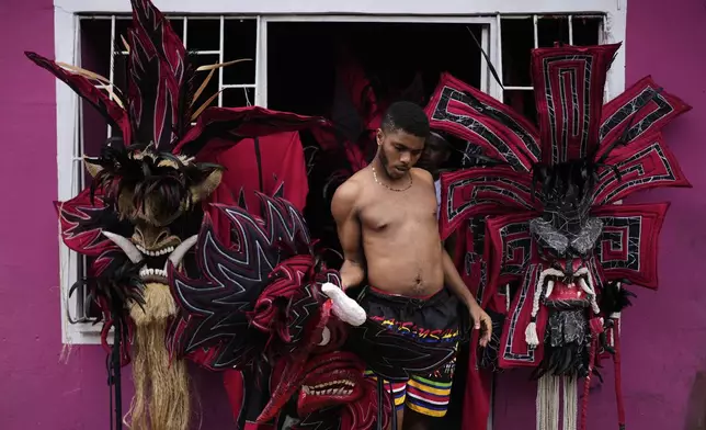 A reveler prepares his outfit to take part in the Devils and Congos Festival in Portobelo, Panama, Saturday, May 3, 2025. (AP Photo/Matias Delacroix)