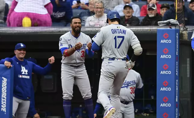 Los Angeles Dodgers' Shohei Ohtani is congratulated by Teoscar Hernandez after hitting a two run home run off Cleveland Guardians starting pitcher Tanner Bibee during the fourth inning of a baseball game, Tuesday, May 27, 2025, in Cleveland. (AP Photo/David Dermer)