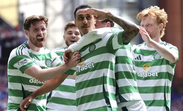 Celtic's Adam Idah, center, celebrates scoring their side's first goal of the game with teammates during the Scottish Premiership soccer match between Rangers and Celtic at Ibrox Stadium, Glasgow, Scotland, Sunday, May 4, 2025. (Steve Welsh/PA via AP)