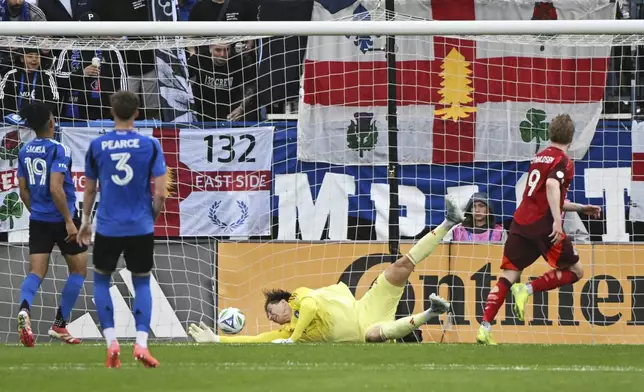 Toronto FC's Ola Brynhildsen (9) scores against CF Montreal goalkeeper Sebastian Breza during the first half of a MLS soccer game in Montreal, Saturday, May 17, 2025. (Graham Hughes/The Canadian Press via AP)