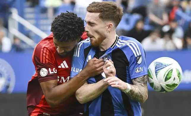 Toronto FC's Kosi Thompson, left, challgenges CF Montreal's Joel Waterman (16) during the first half of a MLS soccer game in Montreal, Saturday, May 17, 2025. (Graham Hughes/The Canadian Press via AP)