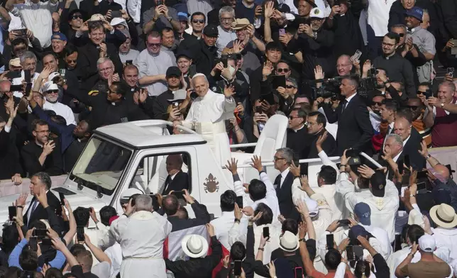 Pope Leo XIV on his popemobile tours St. Peter's Square at the Vatican prior to the inaugural Mass of his pontificate, Sunday, May 18, 2025. (AP Photo/Domenico Stinellis)