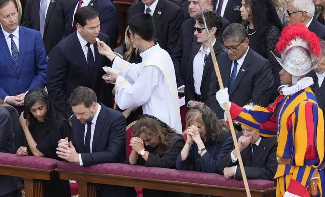Secretary of State Marco Rubio takes the Holy Communion as other delegates including Vice President JD Vance, center-left, and second lady Usha Vance, left, kneel in prayer during a Mass for the formal inauguration of Pope Leo XIV's pontificate, in St. Peter's Square, at the Vatican, Sunday, May 18, 2025. (AP Photo/Gregorio Borgia)