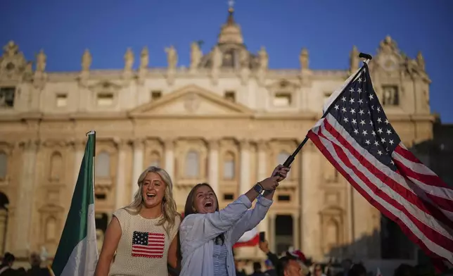 A woman waves a United States flag ahead of Pope Leo XIV's formal inauguration of his pontificate with a Mass in St. Peter's Square attended by heads of state, royalty and ordinary faithful, Sunday, May 18, 2025. (AP Photo/Andrew Medichini)