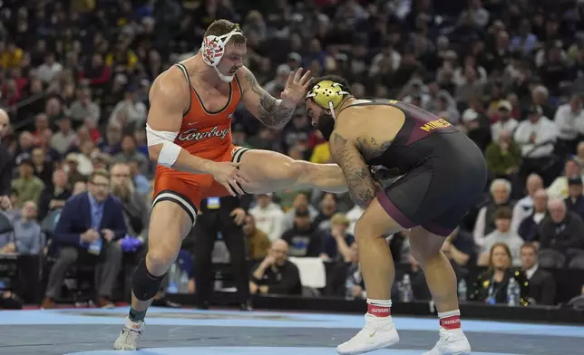 FILE - Oklahoma State's Wyatt Hendrickson, left, takes on Minnesota's Gable Steveson during a 285-pound match in the finals at the NCAA wrestling championship, Saturday, March 22, 2025, in Philadelphia. (AP Photo/Matt Rourke, File)