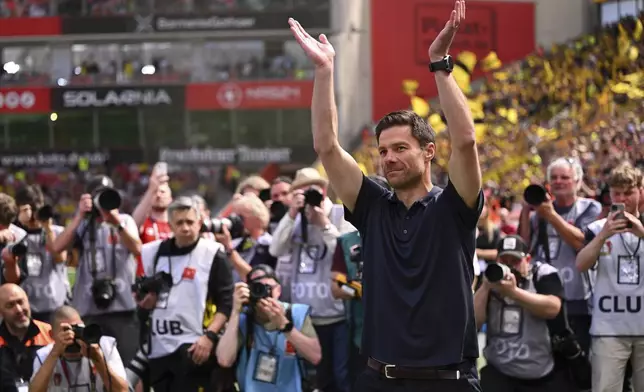 Leverkusen's head coach Xabi Alonso waves to the fans before the German Bundesliga soccer match between Bayer 04 Leverkusen and Borussia Dortmund in Leverkusen, Germany, Sunday, May 11, 2025. (Marius Becker/dpa via AP)