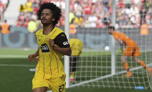 Dortmund's Karim Adeyemi celebrates after scoring his side's third goal during the German Bundesliga soccer match between Bayer 04 Leverkusen and Borussia Dortmund in Leverkusen, Germany, Sunday, May 11, 2025. (Rolf Vennenbernd/dpa via AP)
