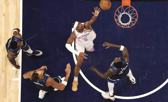 Oklahoma City Thunder guard Shai Gilgeous-Alexander, middle, shoots the ball against the Minnesota Timberwolves during the first half of Game 3 of the Western Conference finals of the NBA basketball playoffs Saturday, May 24, 2025, in Minneapolis. (AP Photo/Matt Krohn)