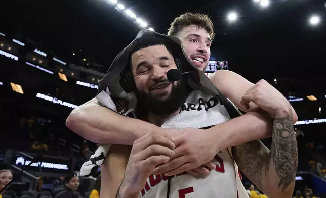 Houston Rockets guard Fred VanVleet (5) is hugged by center Alperen Sengun after the team's victory over the Golden State Warriors in Game 6 of an NBA basketball first-round playoff series Friday, May 2, 2025, in San Francisco. (AP Photo/Godofredo A. Vásquez)