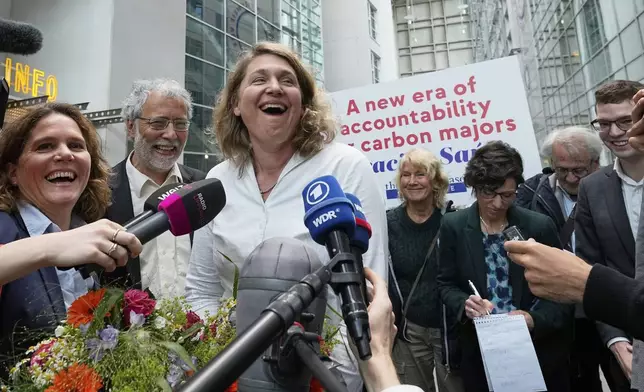 Plaintiff's attorney Roda Verheyen celebrates with her team after the verdict in the climate damages case of plaintiff Peruvian farmer Luciano Lliuya against the German energy company RWE for its carbon emissions, at the Higher Regional Court in Hamm, Germany, Wednesday, May 28, 2025. (AP Photo/Martin Meissner)