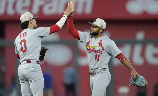 St. Louis Cardinals' Masyn Winn (0) and Victor Scott II (11) celebrate after their baseball game against the Kansas City Royals, Saturday, May 17, 2025, in Kansas City, Mo. (AP Photo/Charlie Riedel)