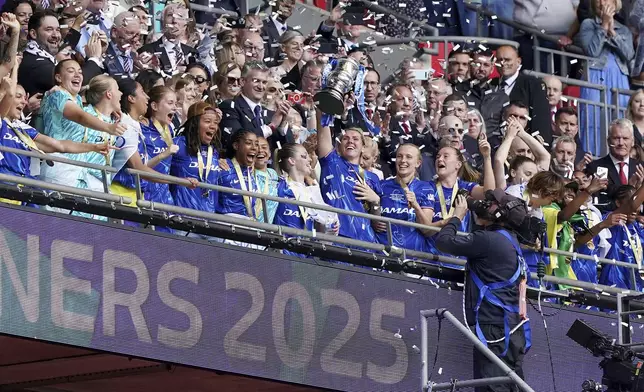 Chelsea's Millie Bright lifts the English Women's FA Cup trophy as she and teammates celebrate winning the final soccer match against Manchester United, at Wembley Stadium, in London, Sunday, May 18, 2025. (Jonathan Brady/PA via AP)