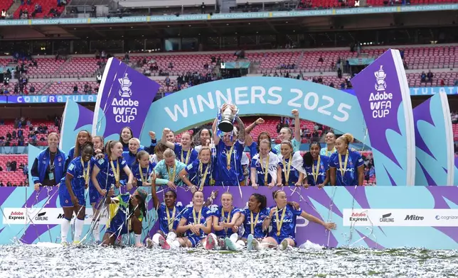 Chelsea's Millie Bright lifts the English Women's FA Cup trophy as she and teammates celebrate winning the final soccer match against Manchester United, at Wembley Stadium, in London, Sunday, May 18, 2025. (John Walton/PA via AP)