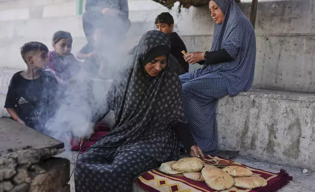Displaced Palestinians prepare bread in a makeshift oven in Gaza City, Monday, May 5, 2025. (AP Photo/Jehad Alshrafi)