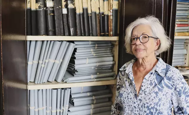 Lilly Duijm poses in front of the boxes of documents from the archive in Paramaribo, Suriname, Friday, May 2, 2025. (AP Photo/Oscar Keur)