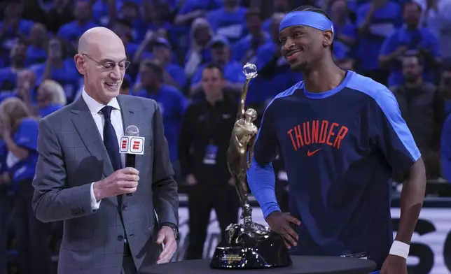 NBA commissioner Adam Silver, left, presents the Michael Jordan Most Valuable Player trophy to Oklahoma City Thunder guard Shai Gilgeous-Alexander prior to Game 2 of an NBA basketball Western Conference Finals playoff series between against the Minnesota Timberwolves Thursday, May 22, 2025, in Oklahoma City. (AP Photo/Nate Billings)