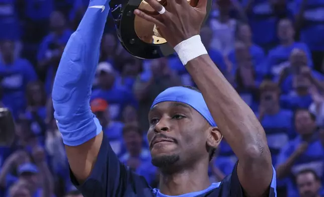 Oklahoma City Thunder guard Shai Gilgeous-Alexander hoists the Michael Jordan Most Valuable Player trophy prior to Game 2 of an NBA basketball Western Conference Finals playoff series between against the Minnesota Timberwolves Thursday, May 22, 2025, in Oklahoma City. (AP Photo/Nate Billings)