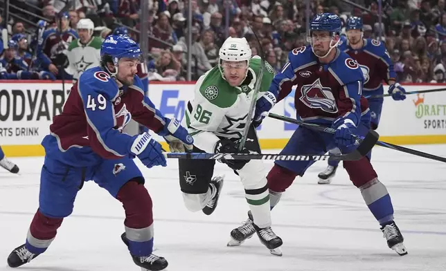 Dallas Stars right wing Mikko Rantanen, center, pursues the puck with Colorado Avalanche defenseman Samuel Girard, left, and center Brock Nelson in the second period of Game 4 of an NHL hockey first-round playoff series Saturday, April 26, 2025, in Denver. (AP Photo/David Zalubowski)