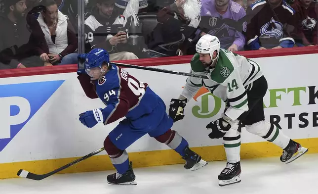 Colorado Avalanche left wing Joel Kiviranta, left, hooks his stick in the jersey of Dallas Stars left wing Jamie Benn in the third period of Game 4 of an NHL hockey first-round playoff series Saturday, April 26, 2025, in Denver. (AP Photo/David Zalubowski)