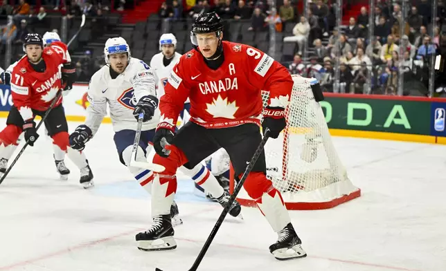 France's Vincent Llorca, and Canada's Nate MacKinnon, right, challenge for the puck during the IIHF Ice Hockey World Championship group A match between Canada and France at Avicii Arena in Stockholm, Sweden, Tuesday May 13, 2025. (Anders Wiklund/TT News Agency via AP)